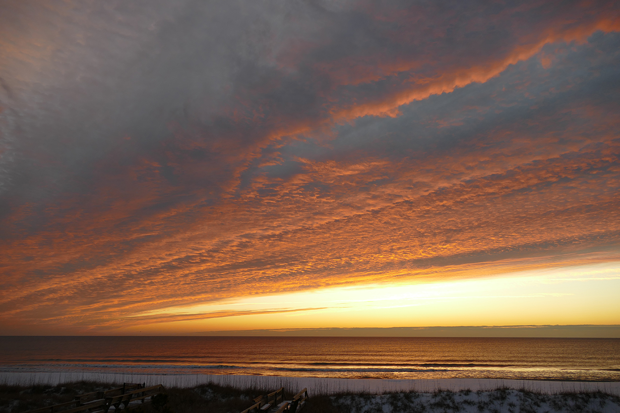 sunrise dramatic orange clouds over snowy beach